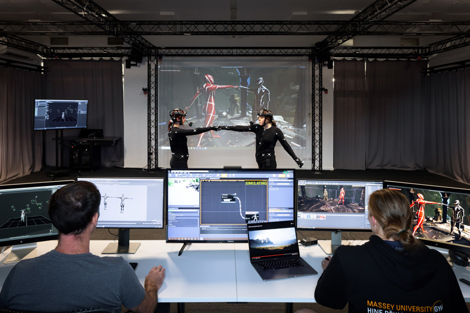 MOCAP studio Students in MOCAP suits in front of projected screen